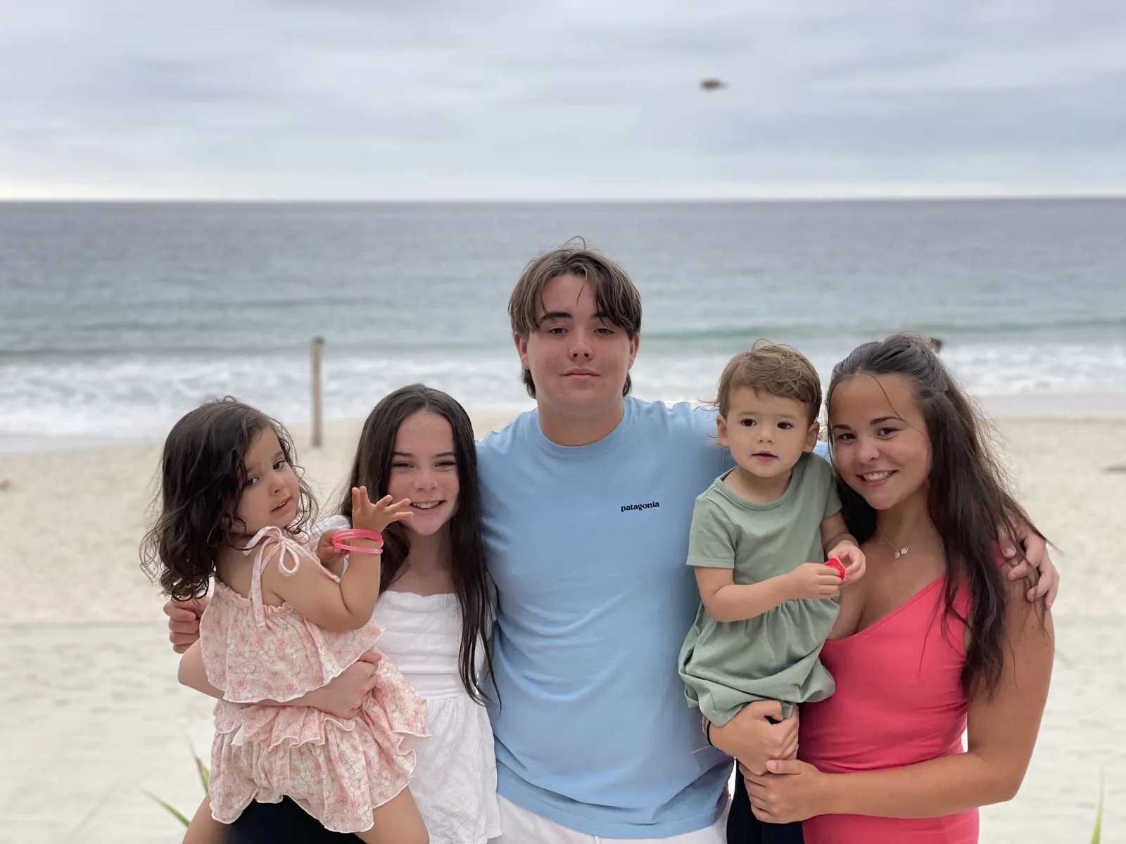 Zoe standing with family on a beach in Mexico