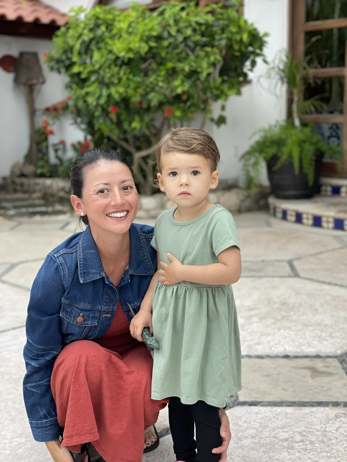 Marie crouching beside Zoe in a courtyard