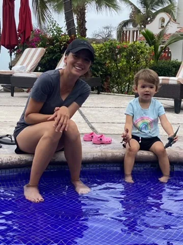 Marie and Zoe sitting at the edge of a blue-tiled pool