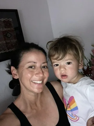Marie holding Zoe for a selfie indoors