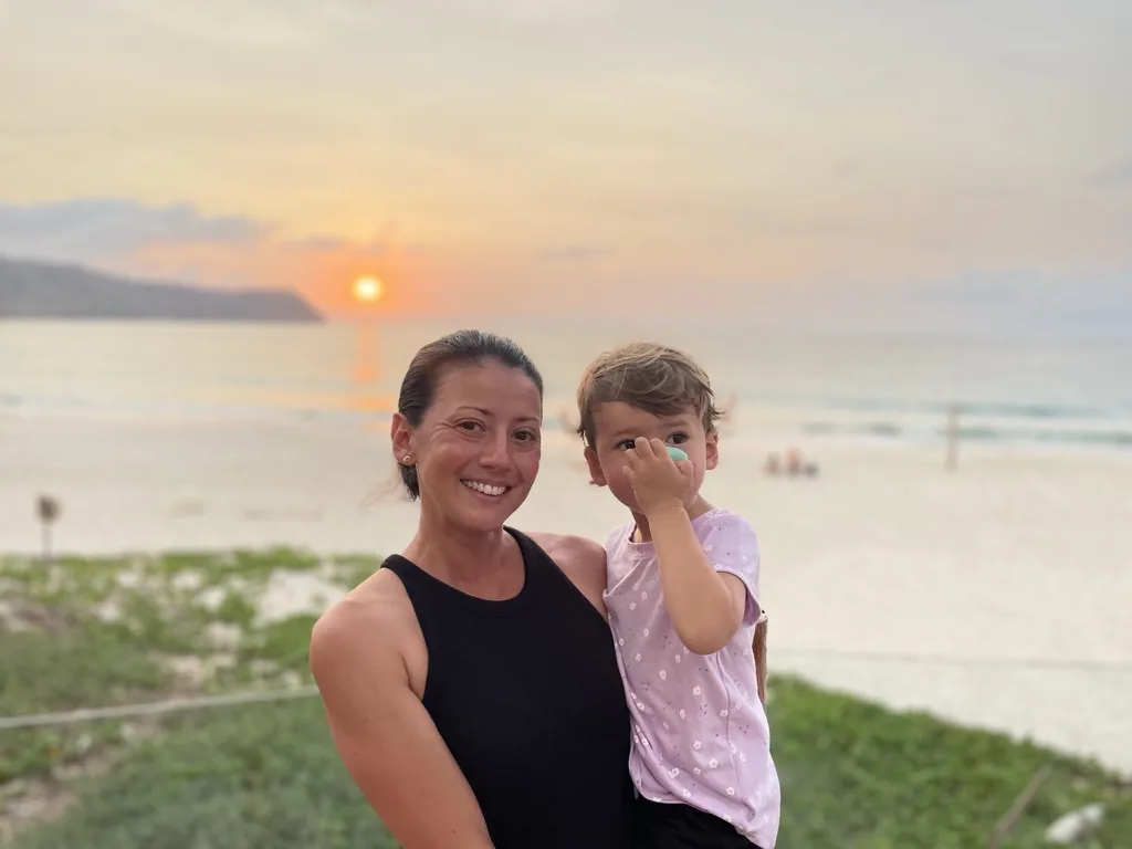 Marie holding Zoe at sunset above the beach