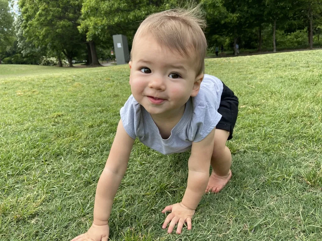 Zoe crawling through grass at an Atlanta park
