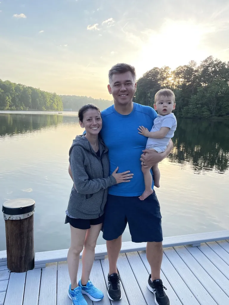 Andrew, Marie, and Zoe standing by a lake at sunset