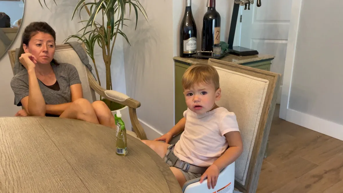 Zoe sitting in a dining chair with Marie nearby
