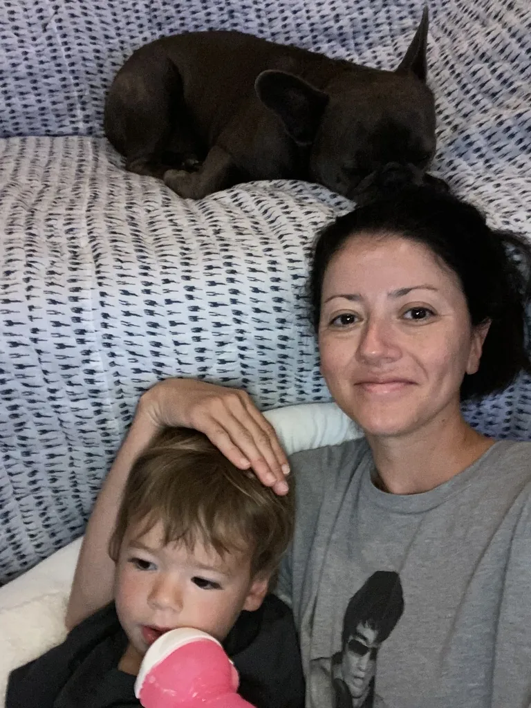 Marie sitting with Zoe on a couch while Francis sleeps behind them