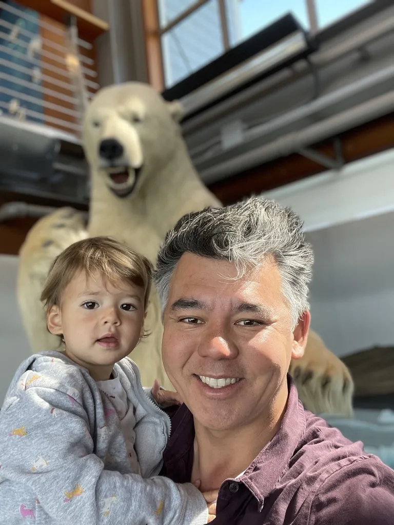 Andrew holding Zoe in front of a polar bear display