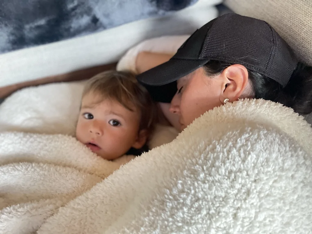 Marie and Zoe cuddled under a white blanket