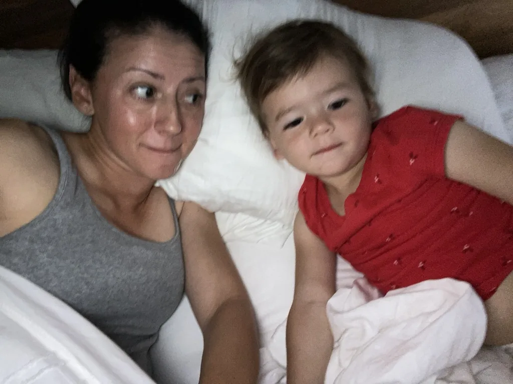 Marie and Zoe lying on a bed for a selfie