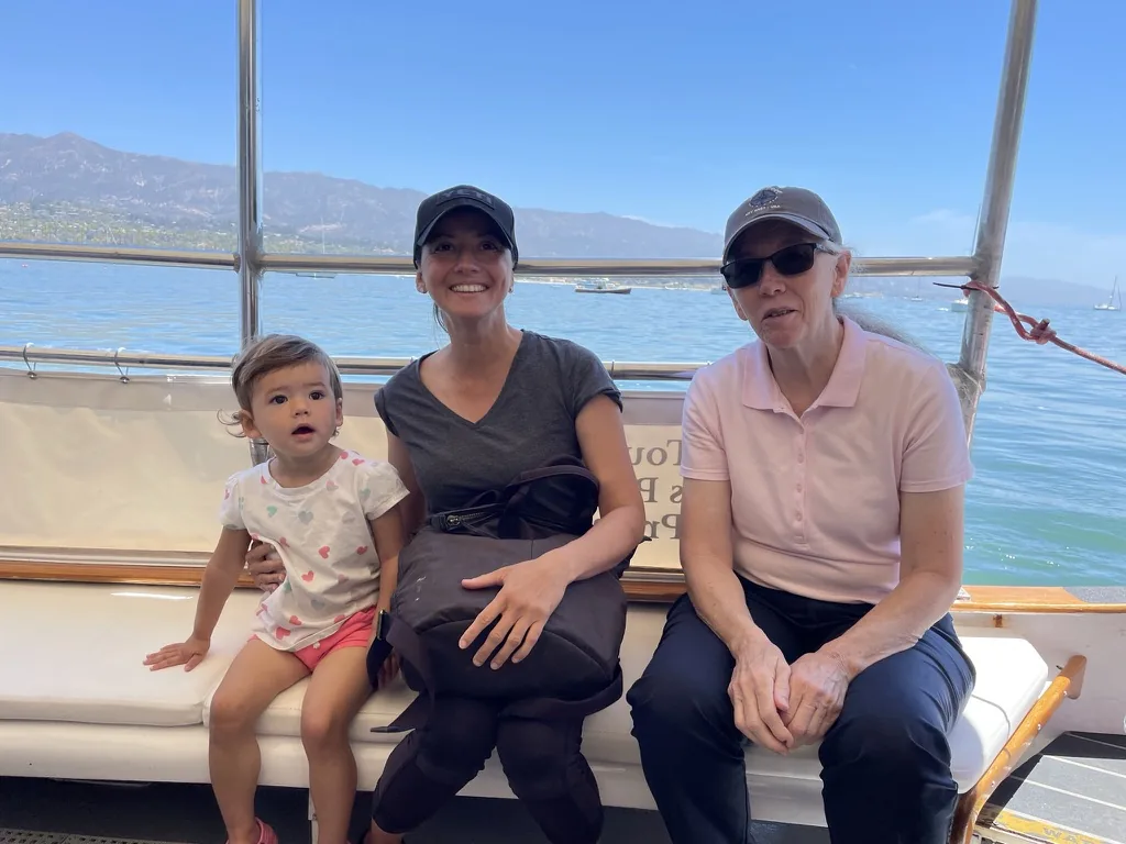 Zoe sitting with Marie and a family member aboard Lil' Toot