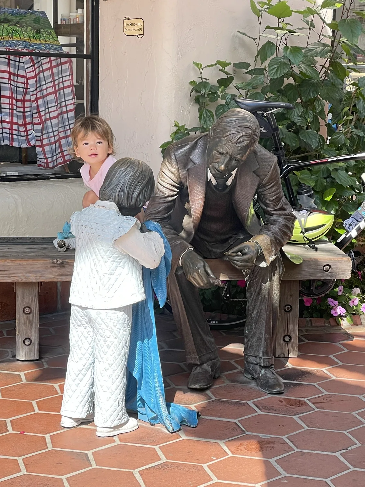 Zoe sitting near bronze bench statues in Montecito