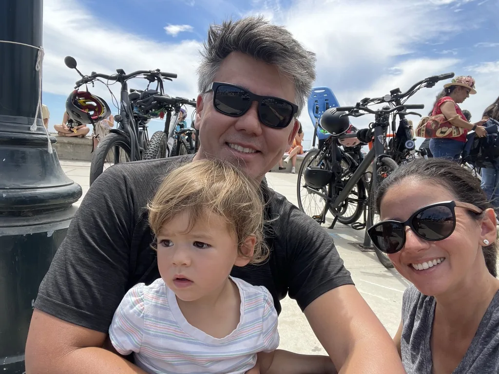 Andrew, Marie, and Zoe sitting together near parked bikes
