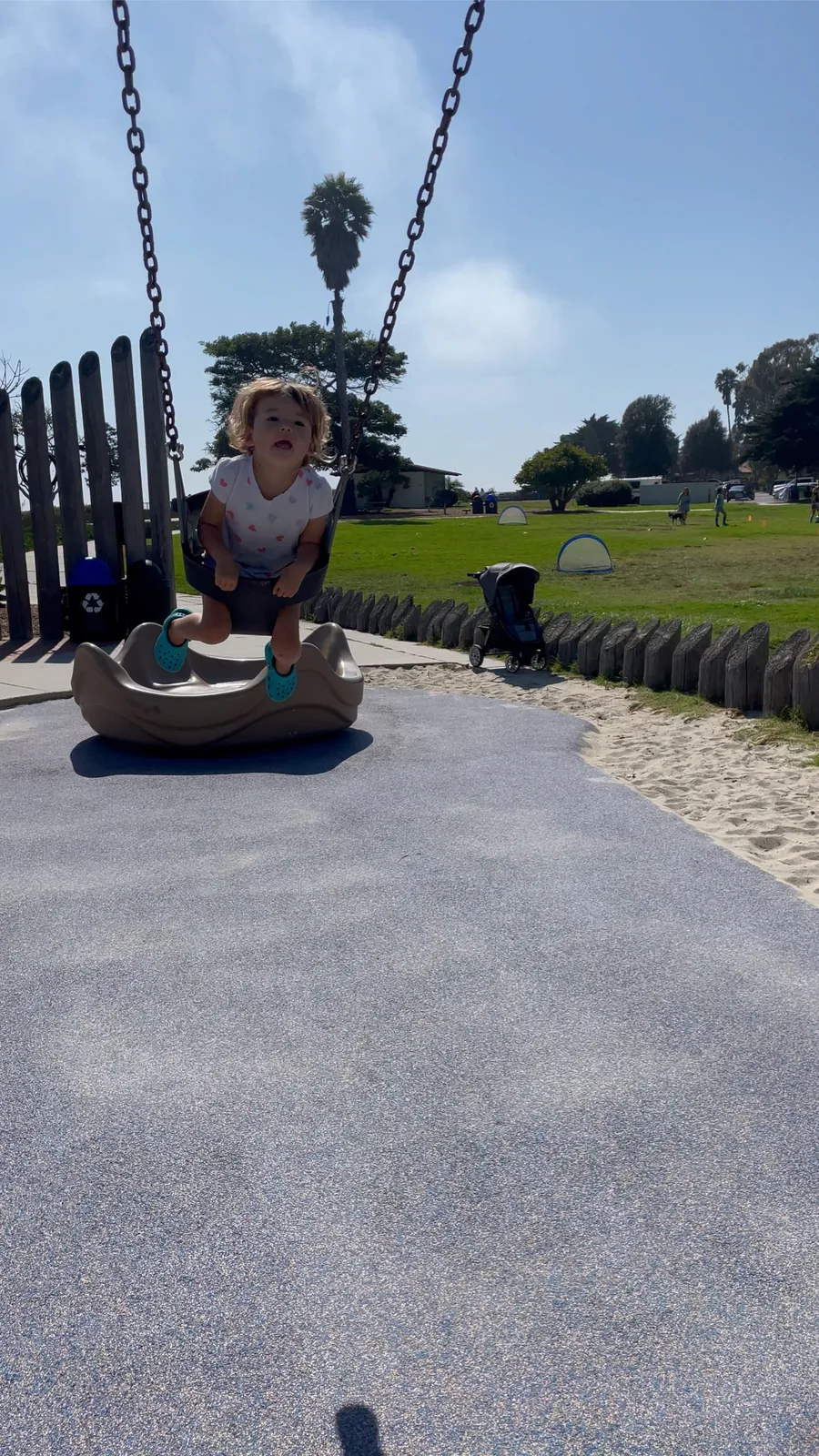 Zoe swinging at a park near the beach