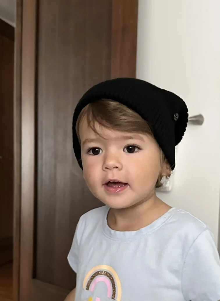 Zoe wearing a black beanie and light blue shirt