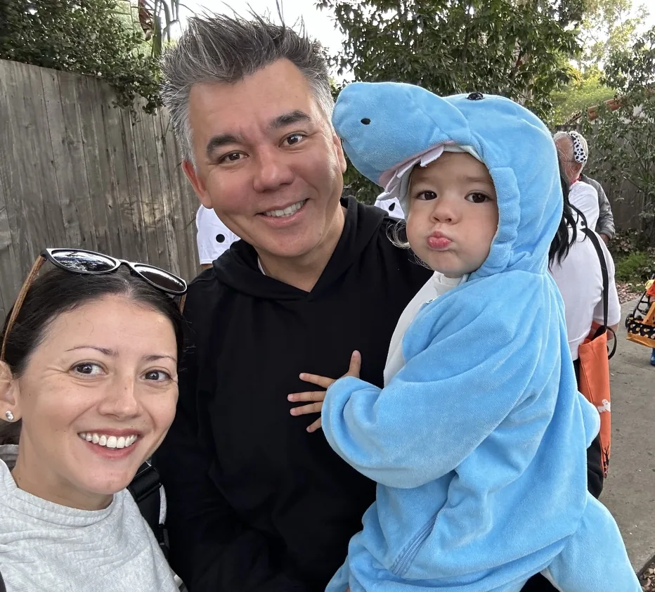 Andrew, Marie, and Zoe in a blue shark hoodie at a Halloween outing