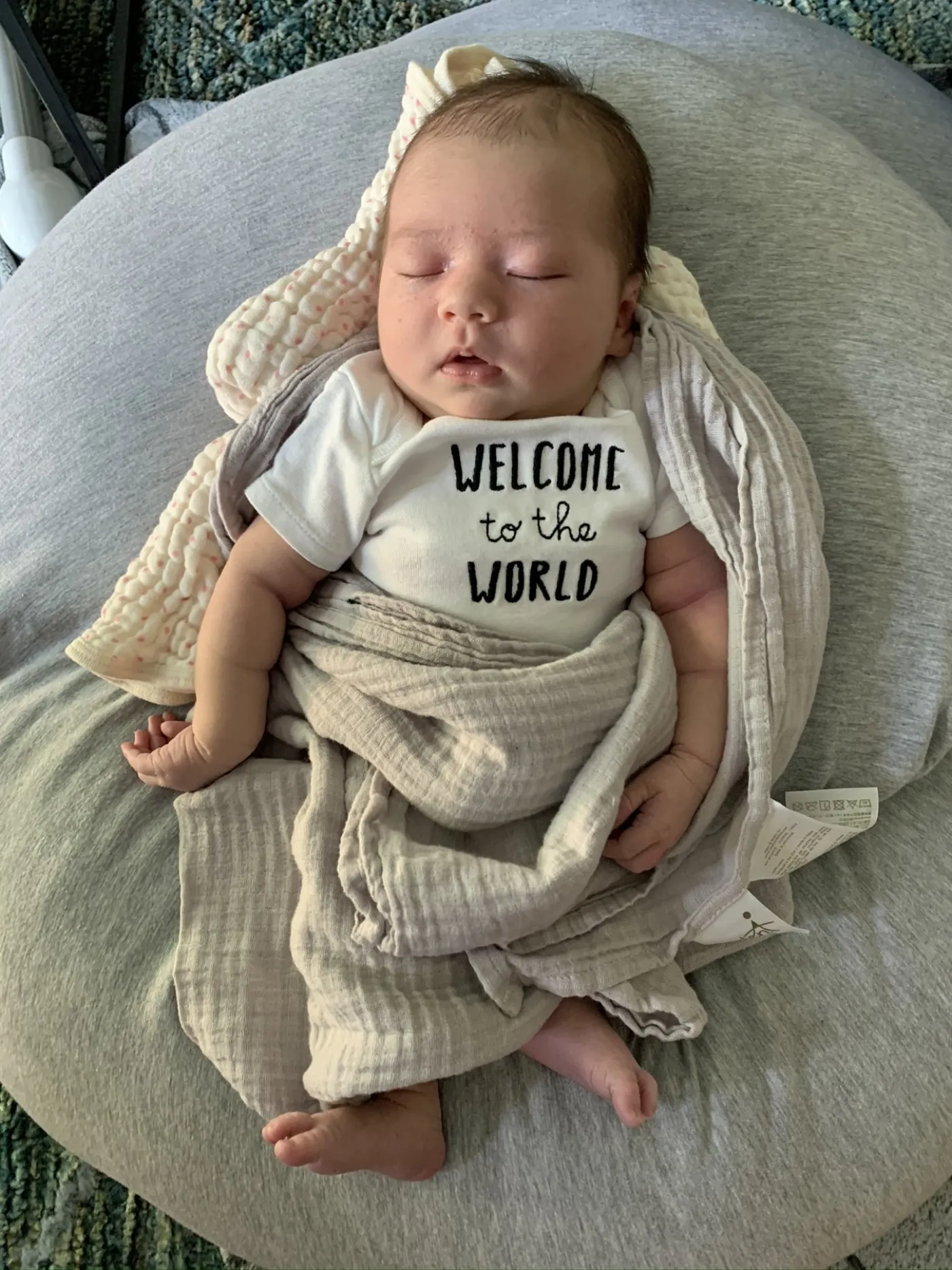 Newborn Zoe wearing a welcome to the world onesie