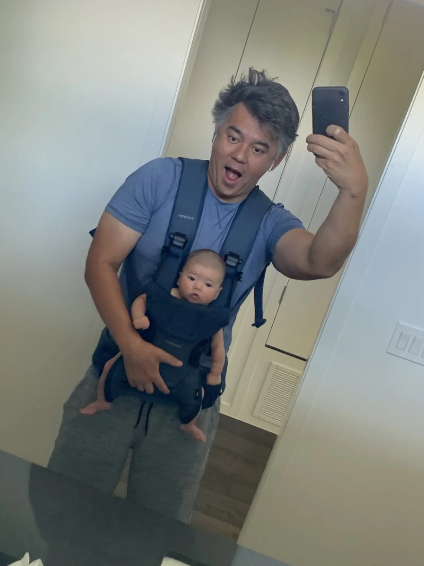 Andrew taking a mirror selfie with baby Zoe in a carrier