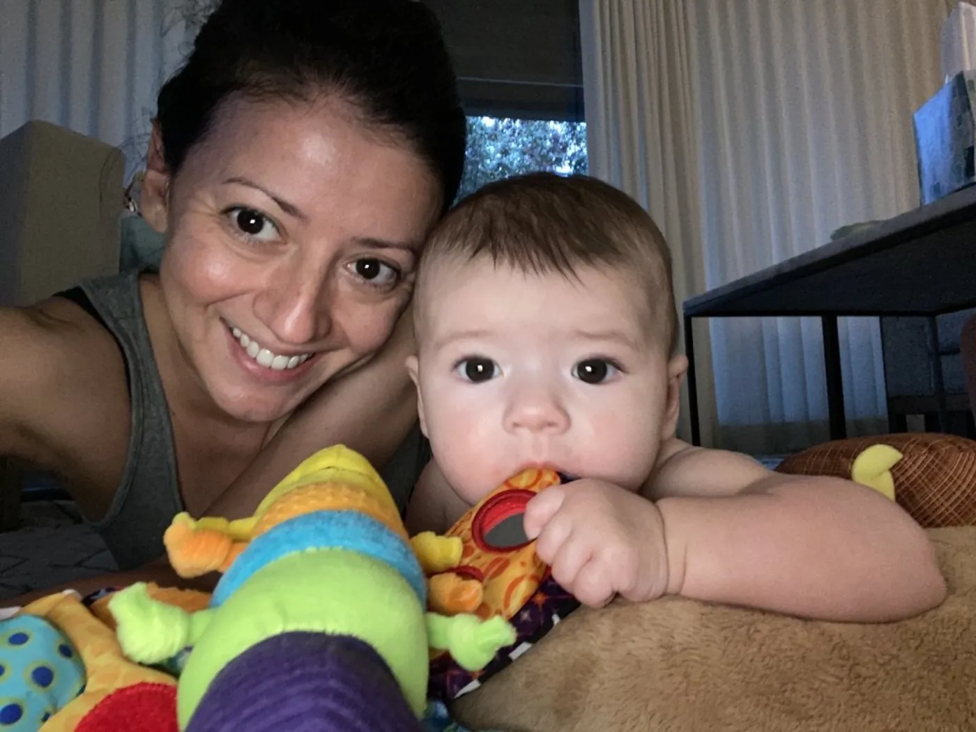 Marie and Zoe on the play mat with a colorful toy