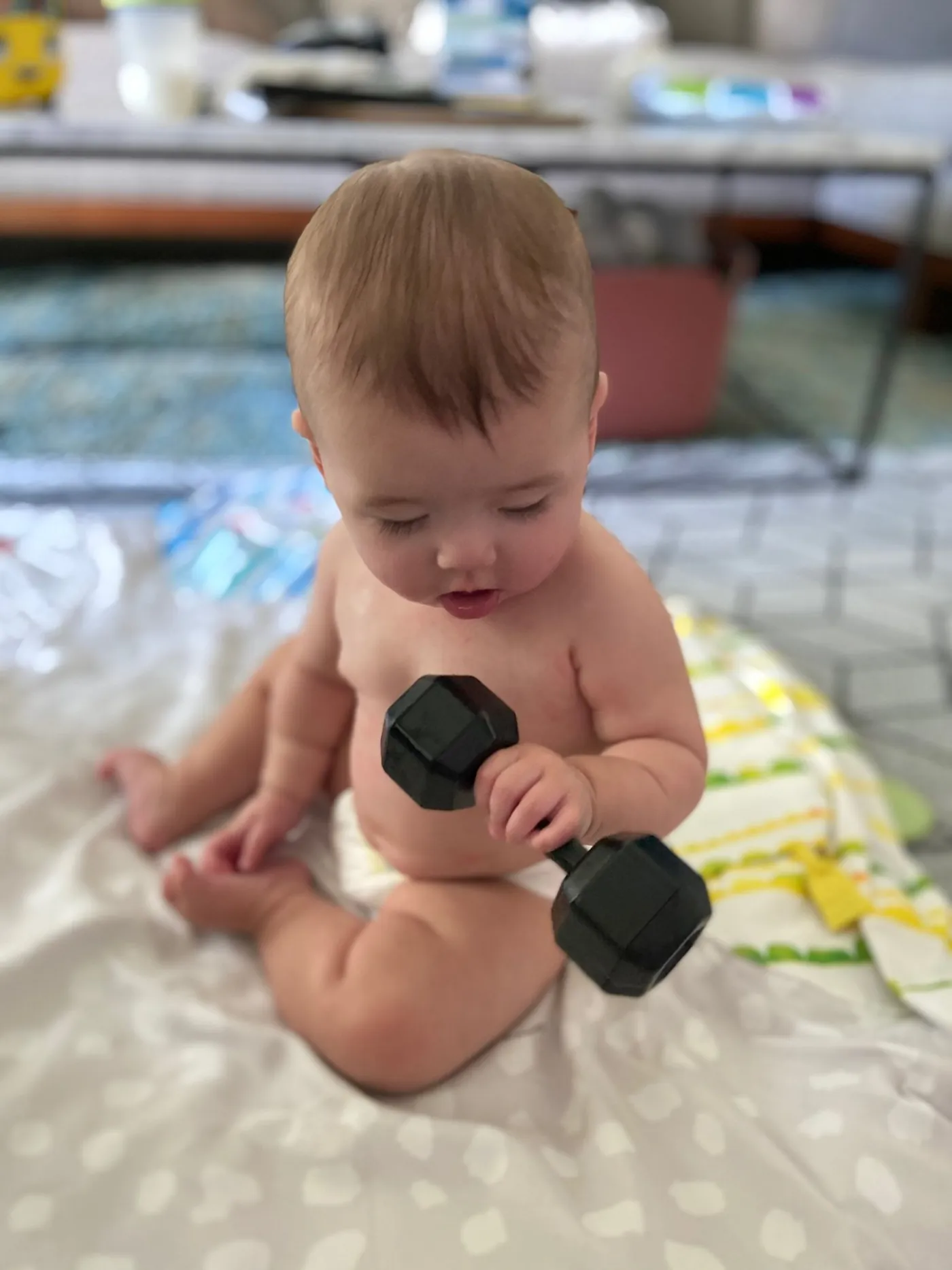 Zoe sitting with a toy dumbbell
