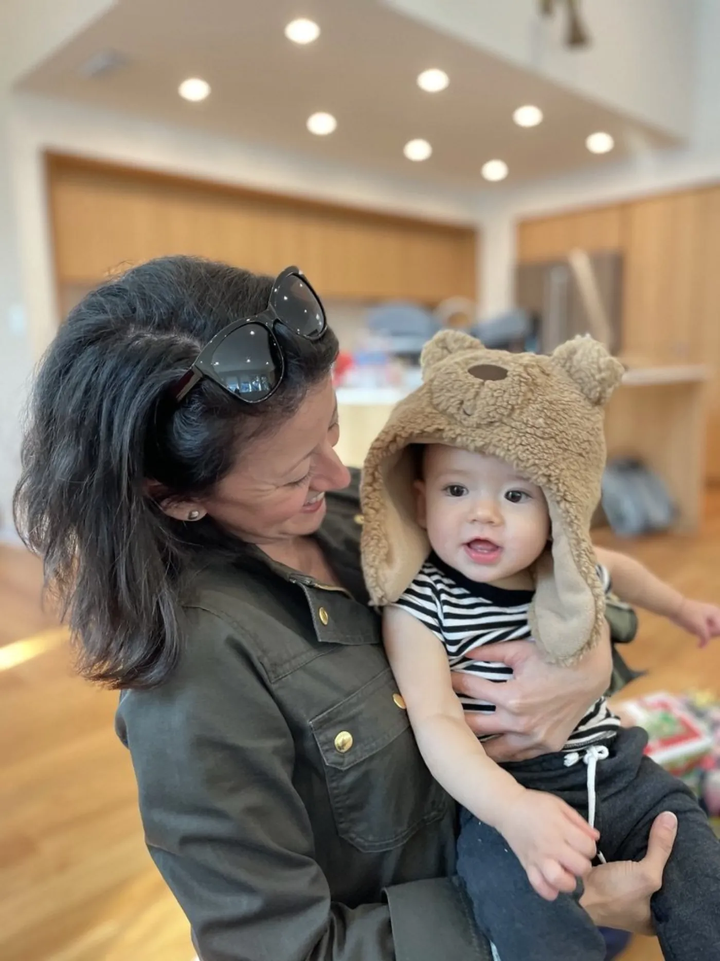 Marie holding Zoe in a plush bear hat on Christmas