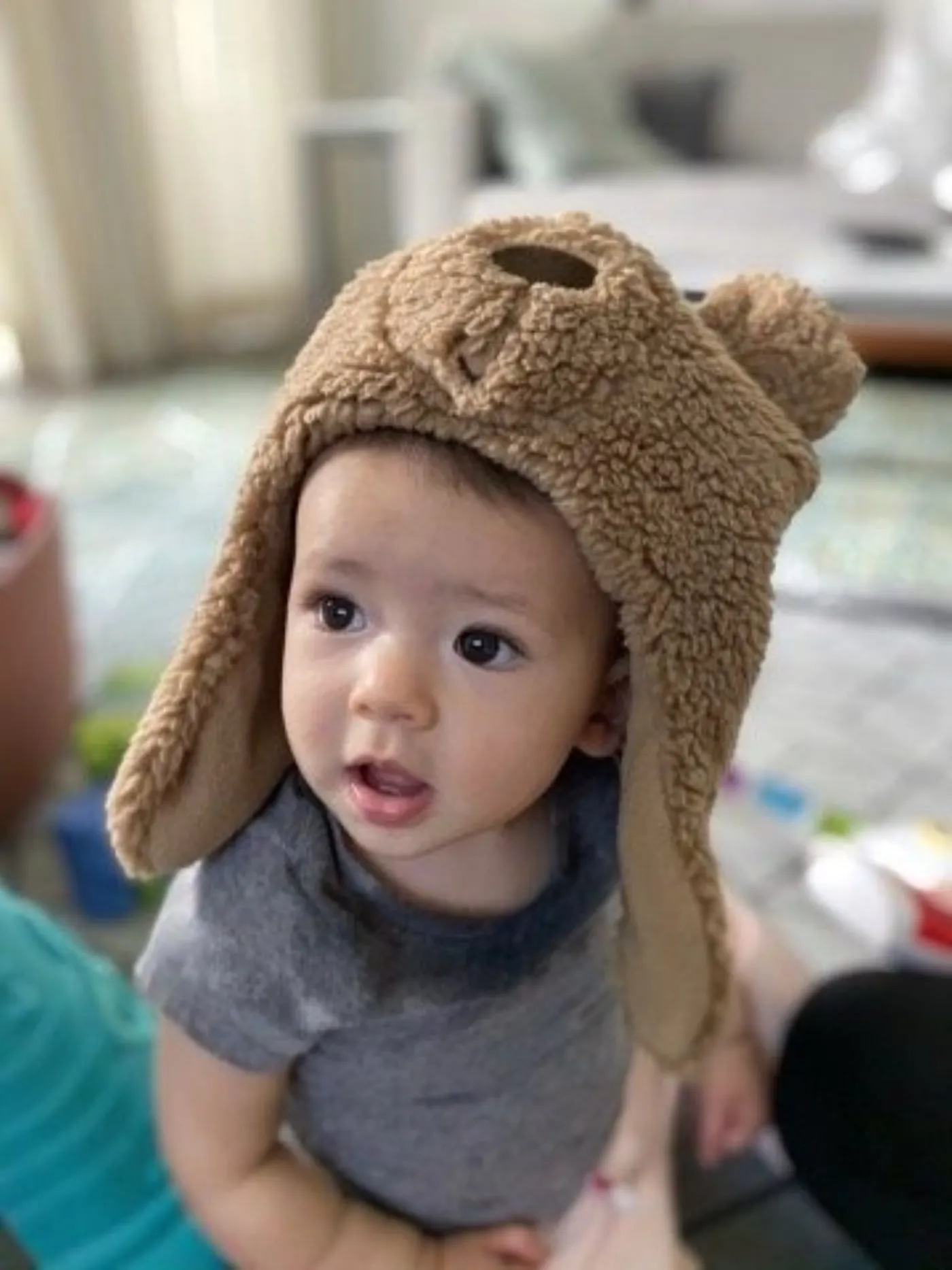Zoe wearing a plush bear hat indoors