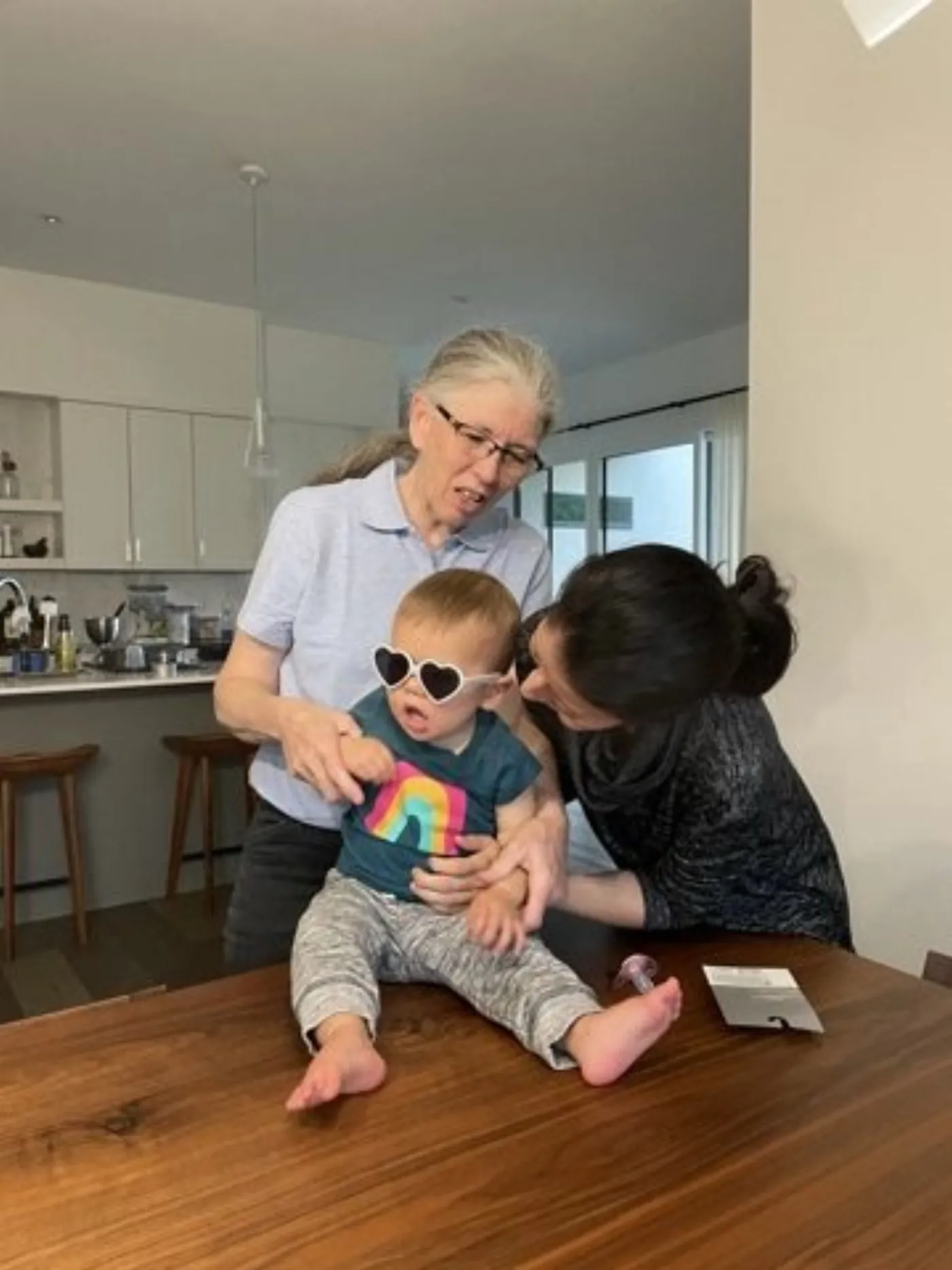 Zoe wearing sunglasses while sitting with family at a table
